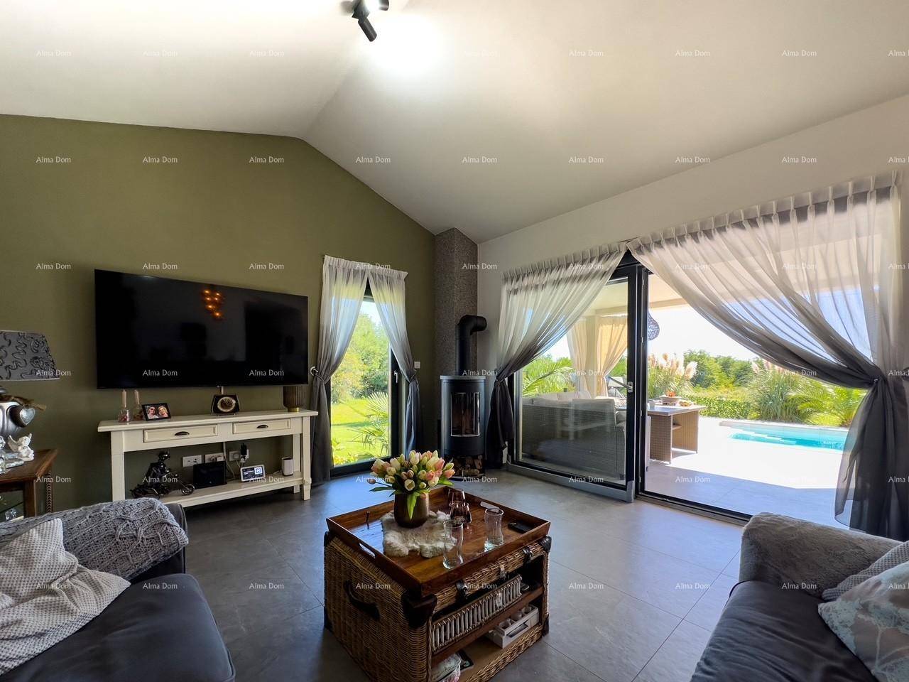 Lichtdurchflutetes Wohnzimmer mit Kaminofen und großen Schiebetüren zur Poolterrasse.
