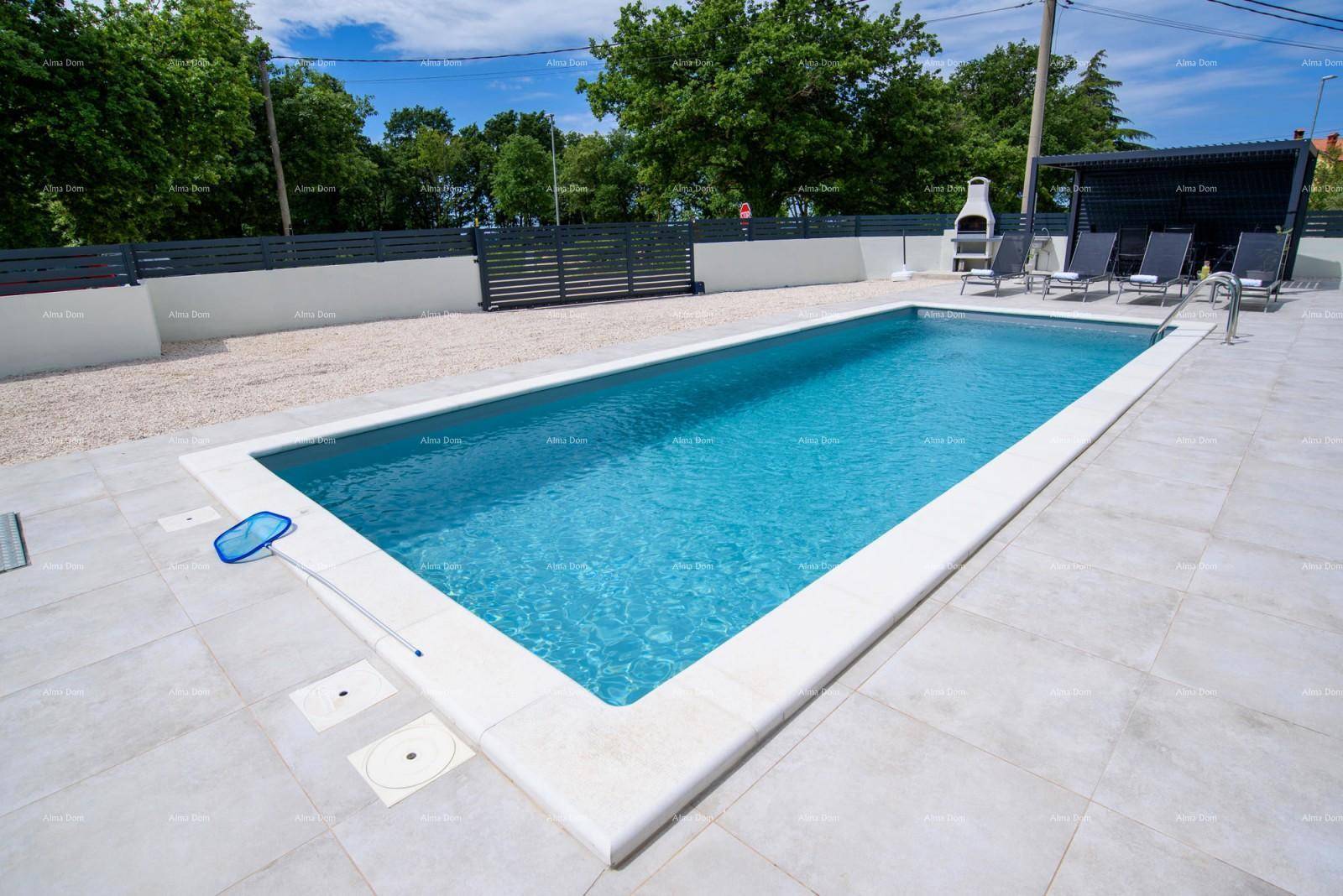 Großzügiger Swimmingpool mit hellen Fliesen am Beckenrand und einer Reinigungsnetzstange.