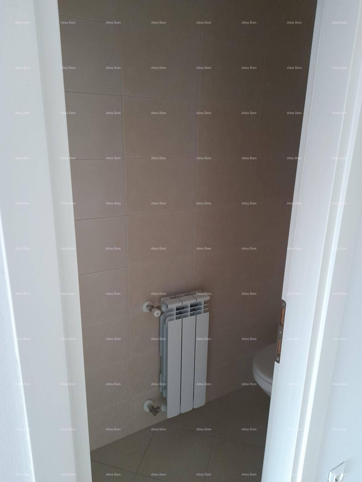 Kleines WC mit Fliesenboden und Heizkörper, durch eine Türöffnung sichtbar.