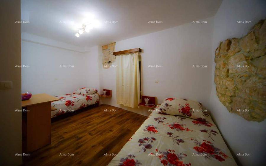 Schlafzimmer mit zwei Einzelbetten, Holzboden und einer dekorativen Steinwand.
