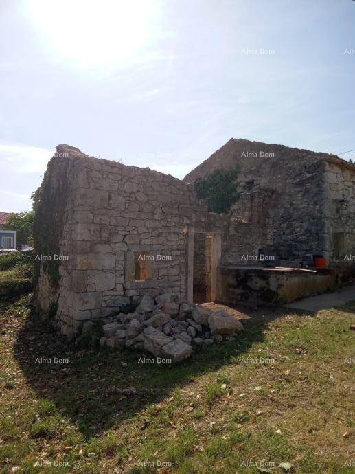 Ruine eines Steinhauses mit fehlendem Dach und offenem Eingangsbereich unter hellem Sonnenlicht.