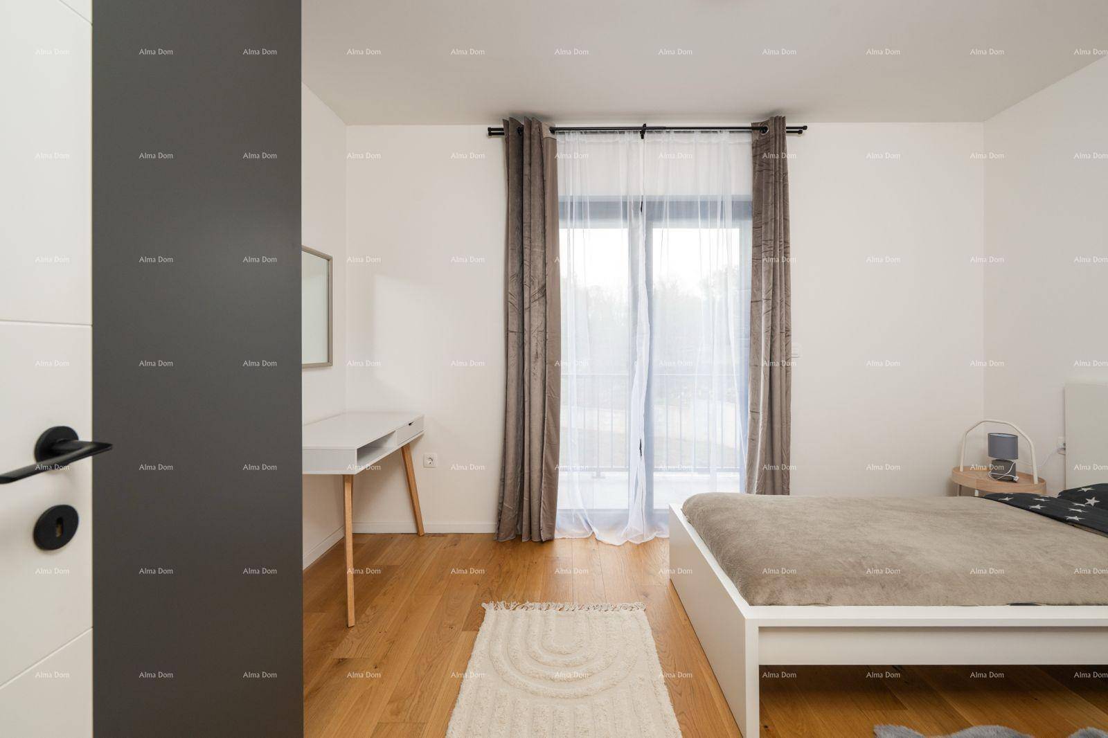 Helles Schlafzimmer mit Holzboden, Schreibtisch und Zugang zu einem Balkon.
