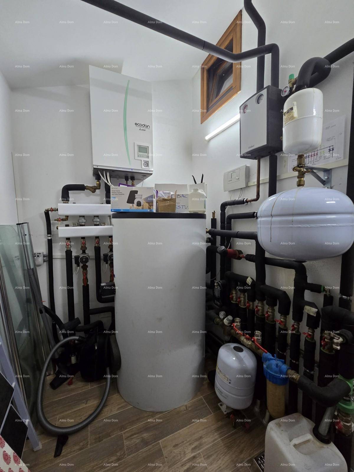 Technikraum mit Heizungsanlage, Warmwasserspeicher und komplexer Rohrinstallation.