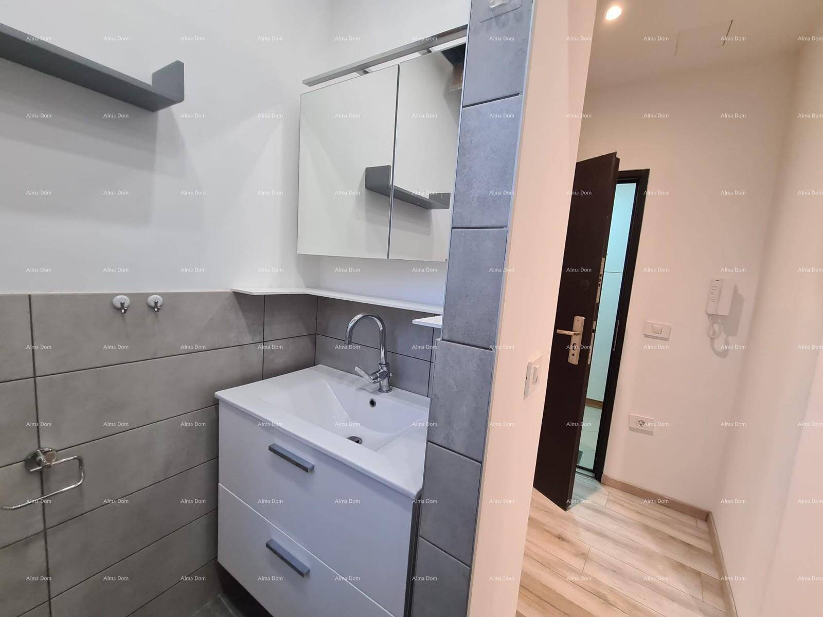 Modernes Badezimmer mit grauen Fliesen, Waschtischunterschrank und Spiegelschrank.