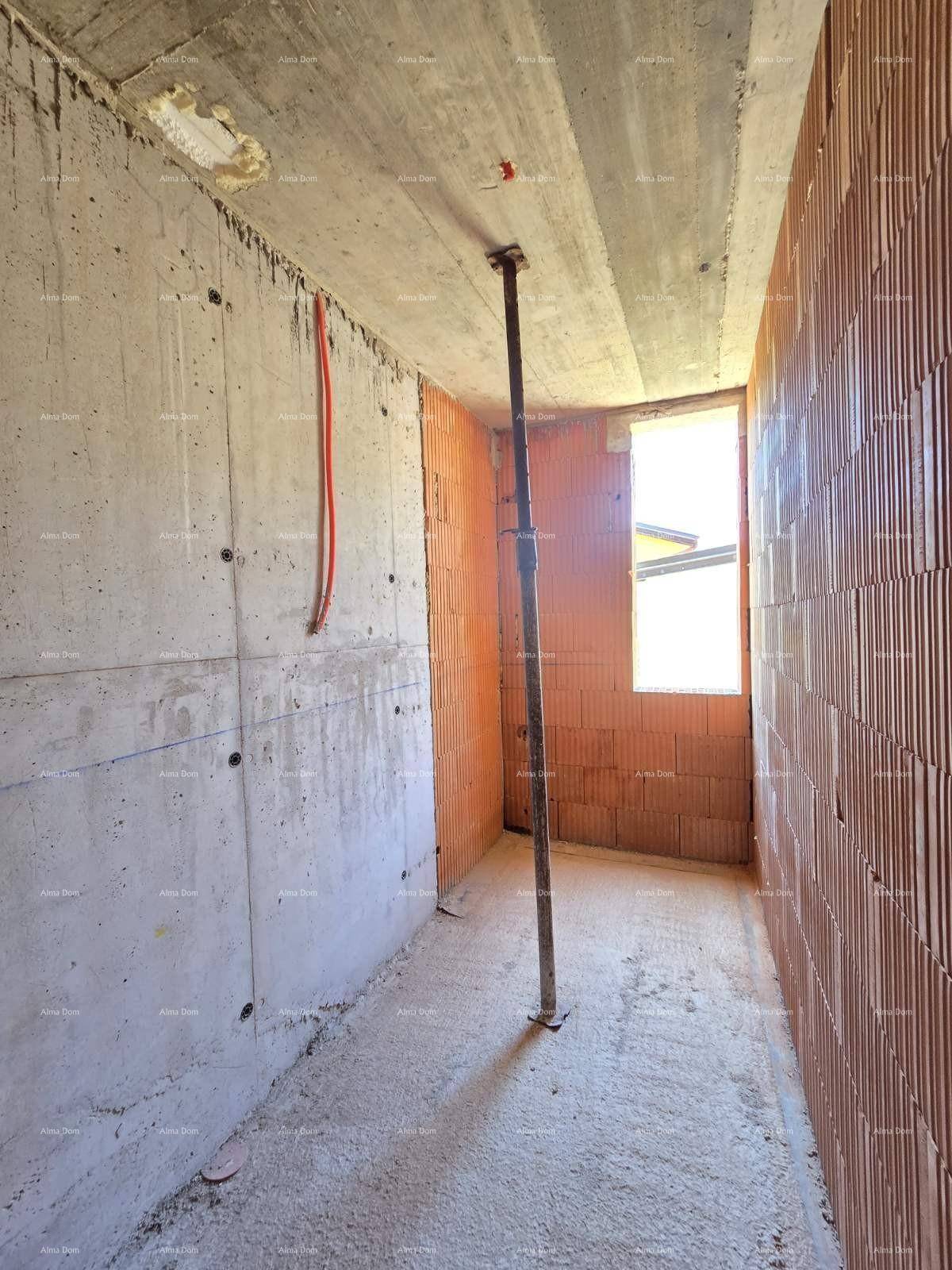 Rohbau eines Raumes mit Beton- und Ziegelwänden, Fenster und einer Deckenstütze.