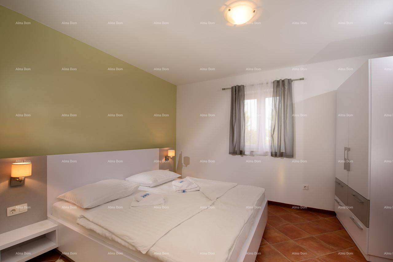 Helles Schlafzimmer mit Doppelbett, Nachttischen und Kleiderschrank.