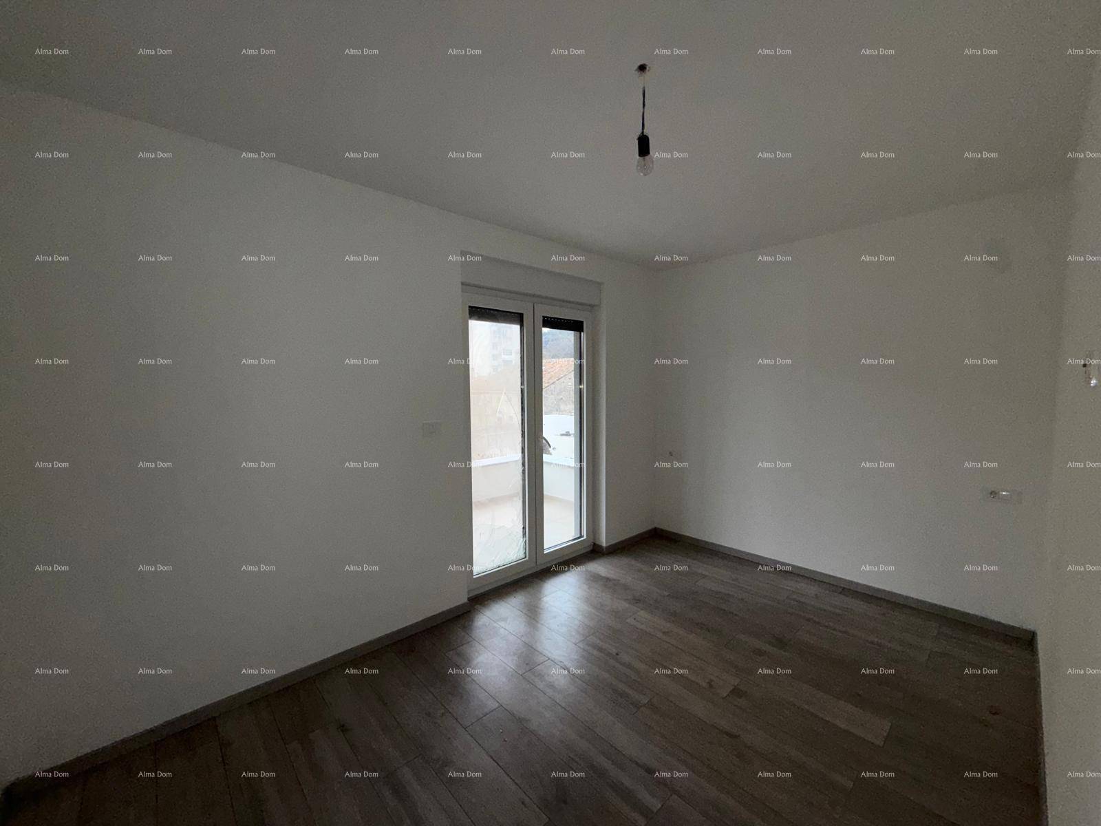 Helles Schlafzimmer mit Holzplankenboden und Zugang zu einem Balkon, bereit zum Einzug.