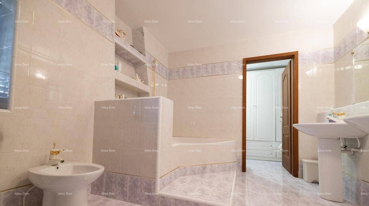 Geräumiges Badezimmer mit eingebauter Badewanne, Bidet und hellen Fliesen.