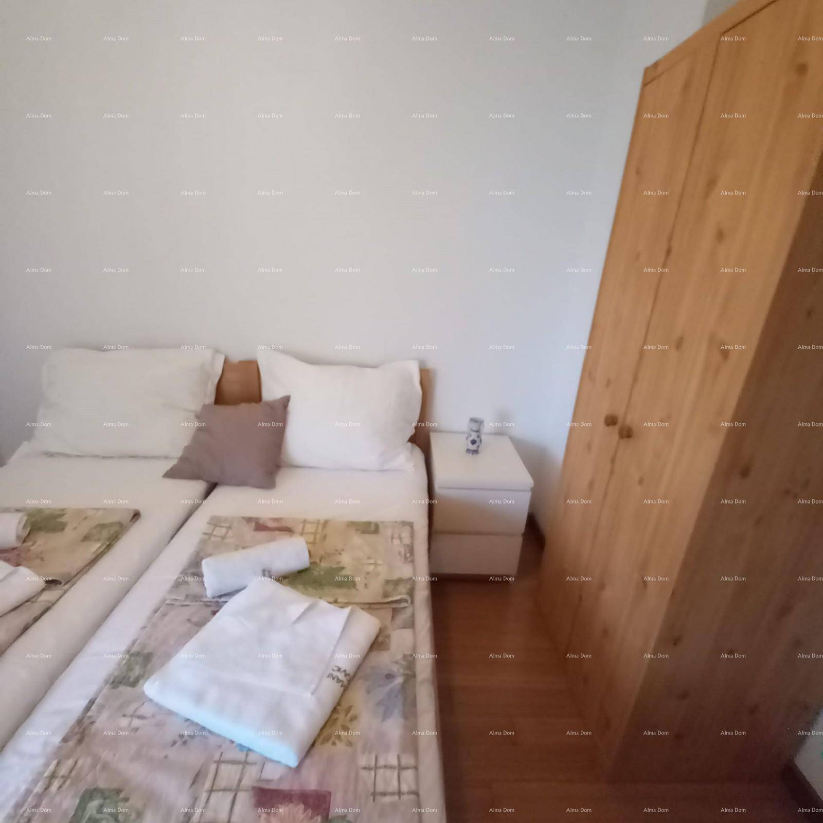 Schlafzimmer mit zwei Einzelbetten, einem Nachttisch und einem Holzschrank, mit Holzboden.