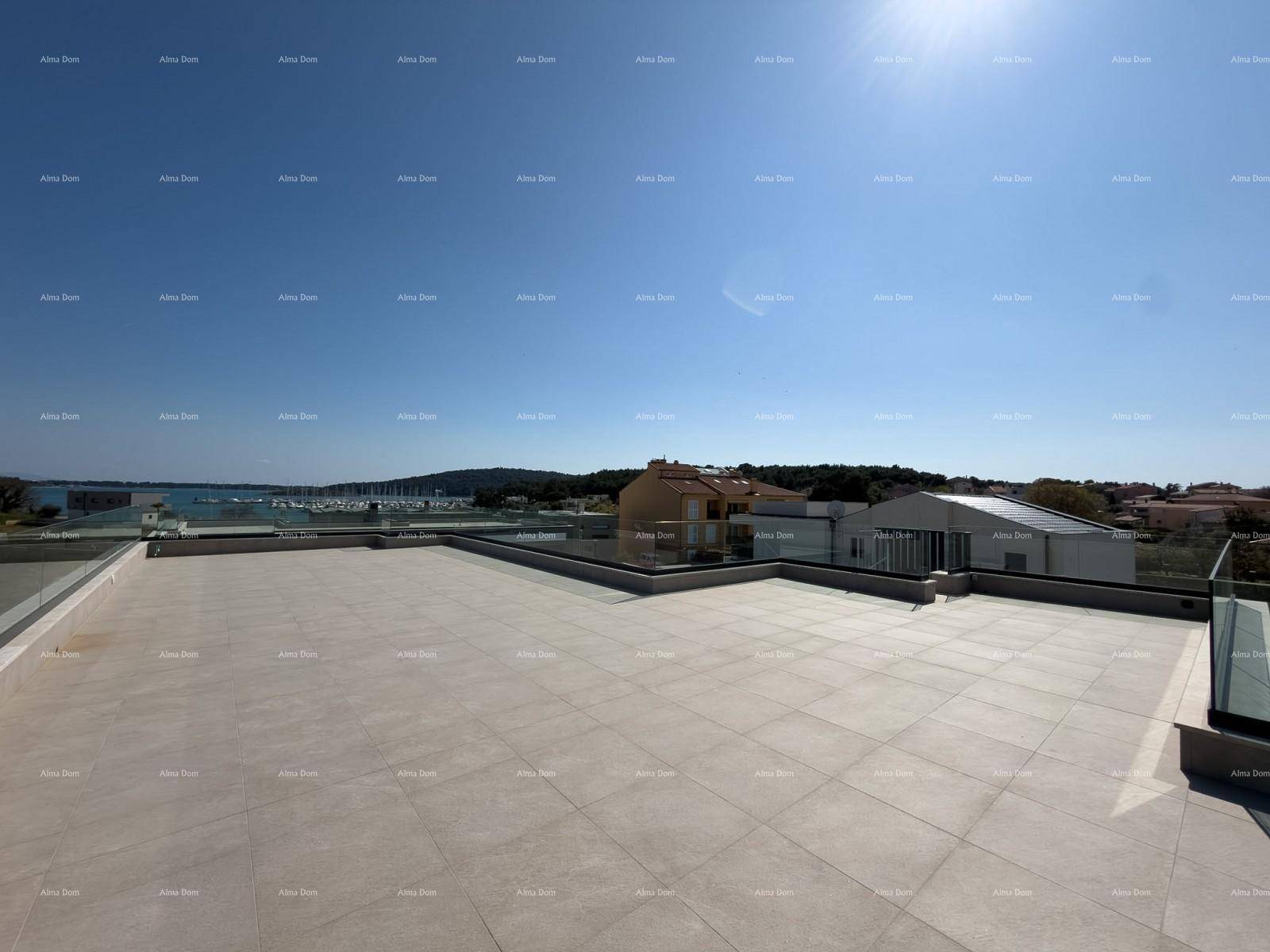 Große Dachterrasse mit Fliesenboden, Glasgeländer und weitem Blick auf das Meer und den Hafen.