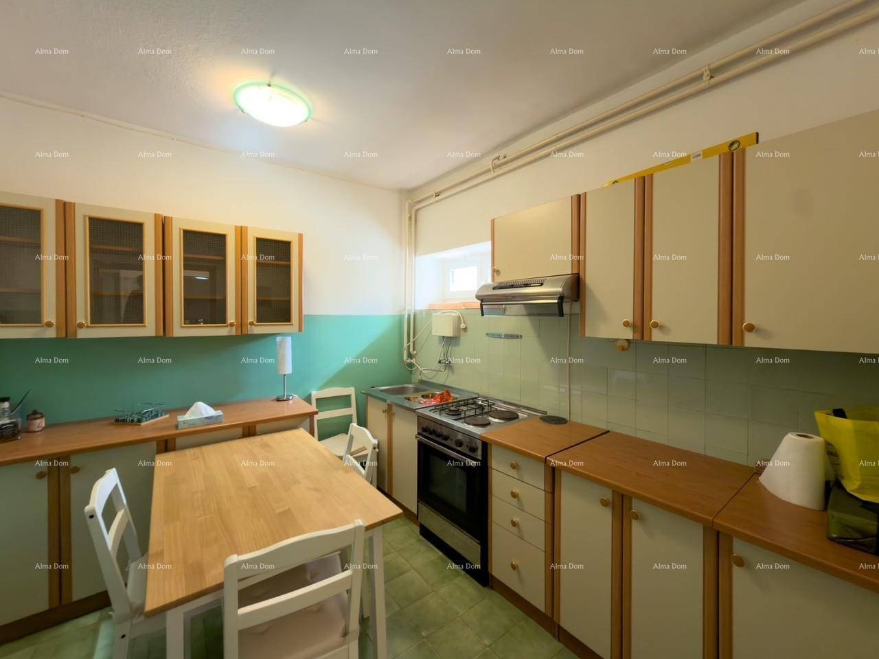 Küche mit hellgrünen Wänden, Holzschränken und Gasherd.