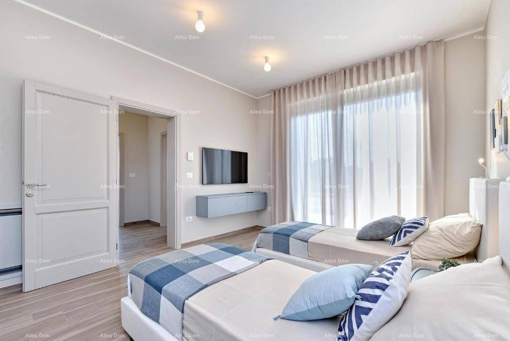 Schlafzimmer mit zwei Betten, Wandfernseher und offener Tür zu einem weiteren Raum.