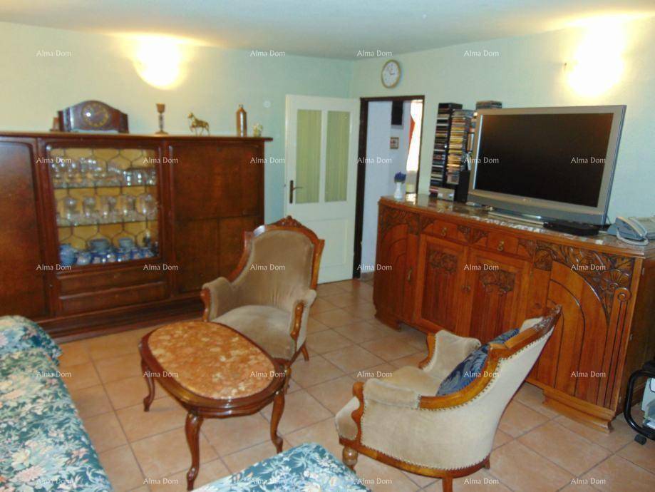 Gemütliches Wohnzimmer mit traditionellen Holzmöbeln, Fliesenboden und einem Fernseher.