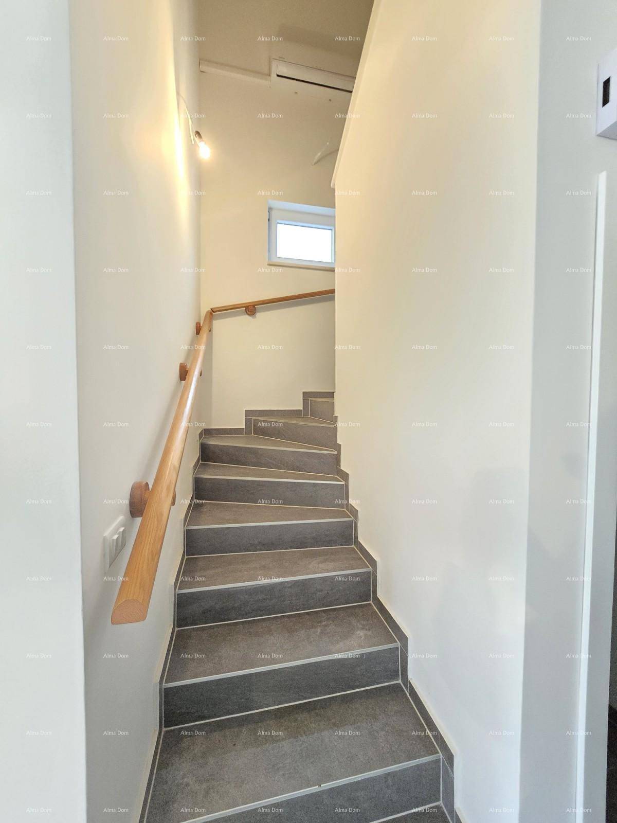 Moderne Treppe mit Holzgeländer und Fliesenstufen, die die Etagen verbindet.