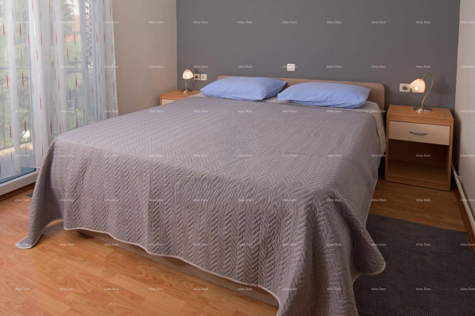 Schlafzimmer mit Doppelbett, Holzboden und Zugang zu einem Balkon.
