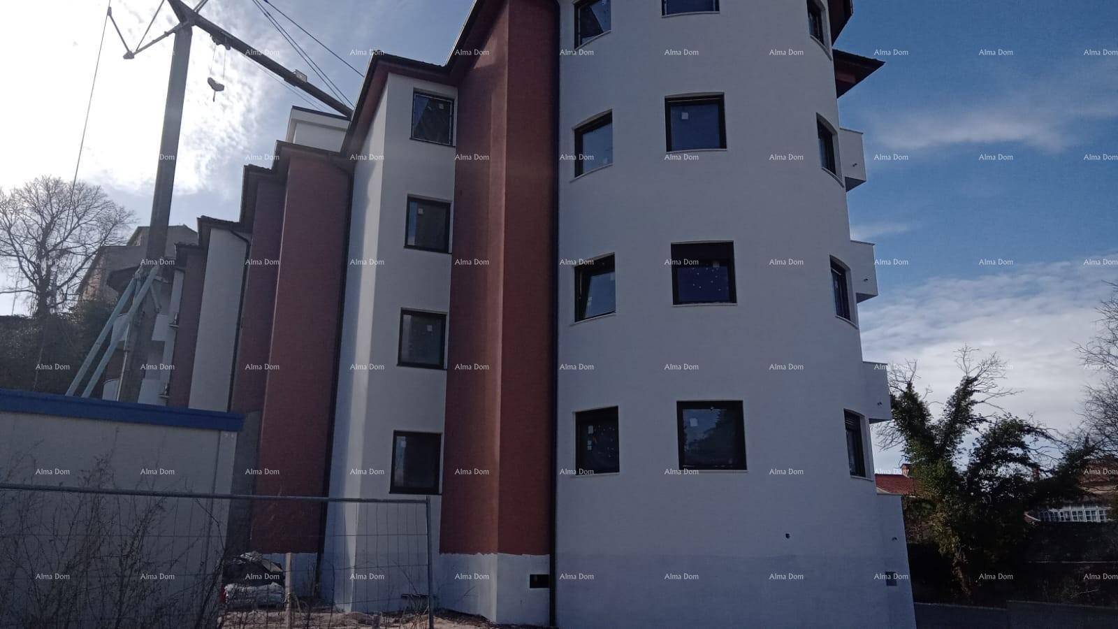 Fassade eines Neubaus mit runden Elementen und Baugerüst im Hintergrund.