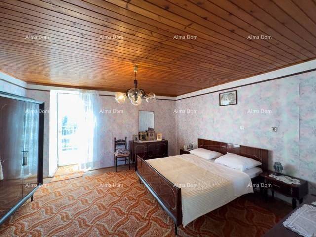Schlafzimmer mit Holzdecke, gemusterter Tapete und einem Doppelbett, das einen traditionellen Charme ausstrahlt.