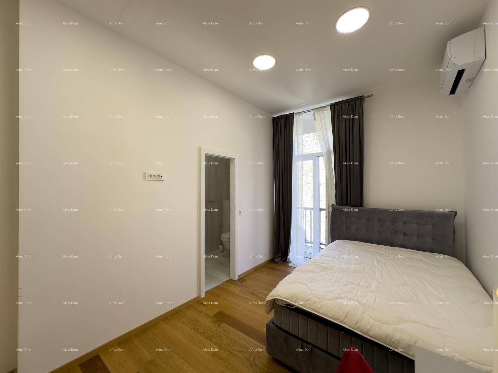 Gemütliches Schlafzimmer mit Holzboden, Doppelbett und Zugang zu einem kleinen Balkon.
