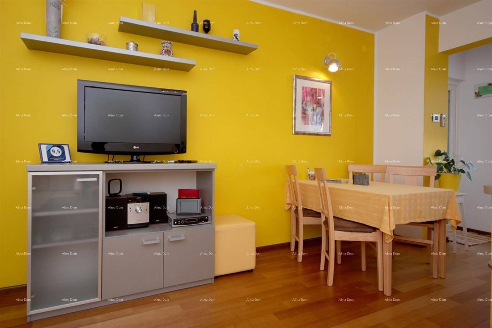 Wohnbereich mit Fernseher, Esstisch und gelben Wänden, hell und freundlich.