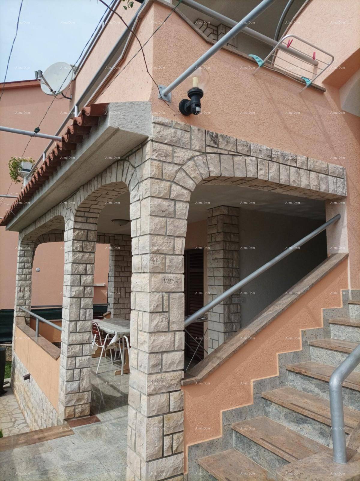 Überdachte Loggia mit Steinbögen und Treppenaufgang, bietet einen geschützten Außenbereich.