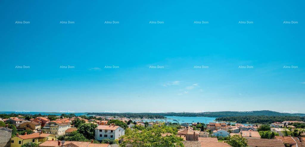 Weitläufiger Panoramablick über die Küstenlandschaft mit vielen Häusern und dem blauen Meer.