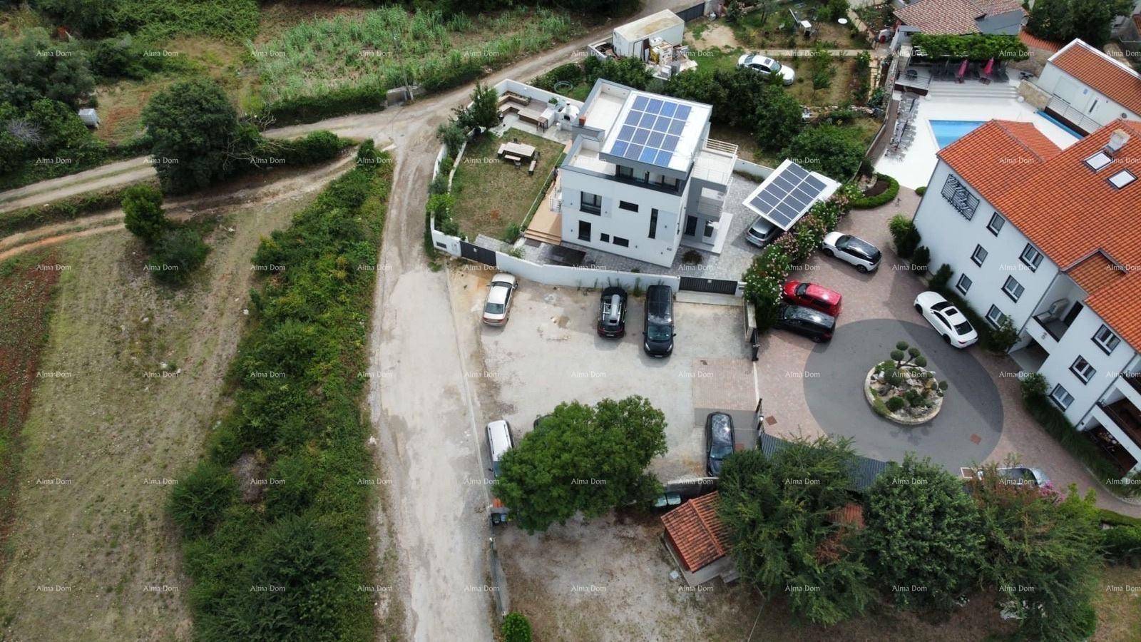 Luftaufnahme der modernen Villa mit Solaranlage, Pool und umliegendem Grundstück.