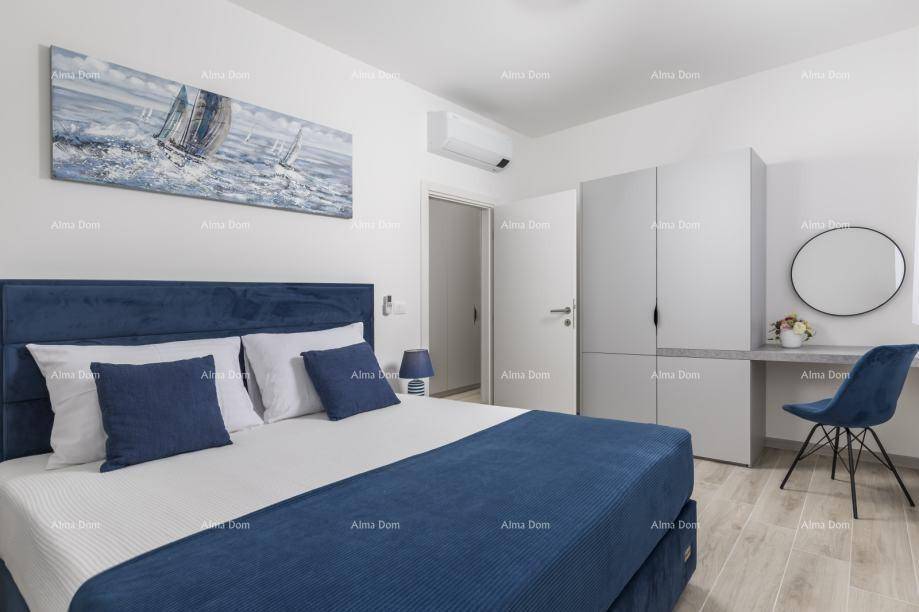 Stilvolles Schlafzimmer mit blauem Doppelbett, passender Dekoration und Schreibtisch.