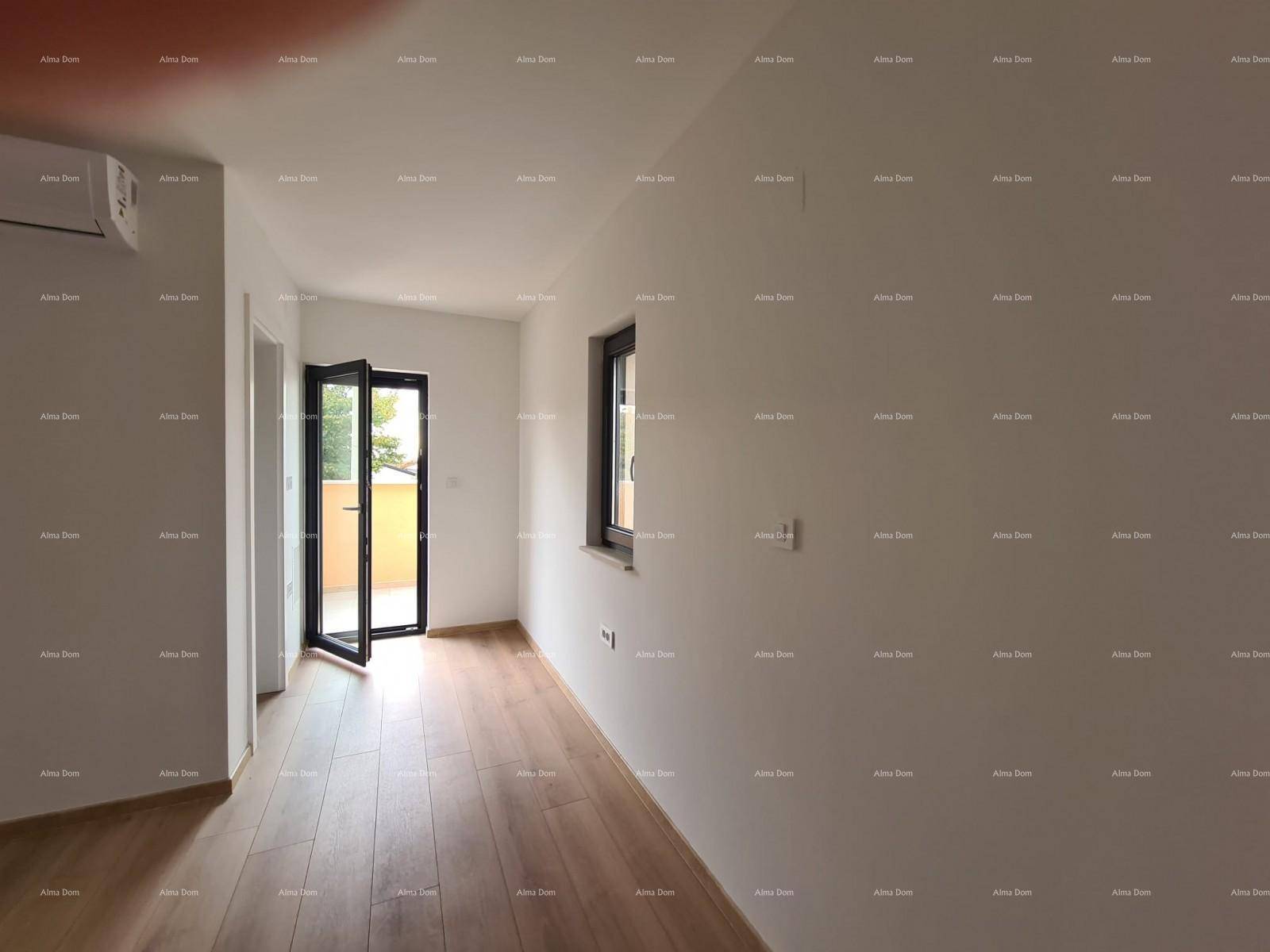 Helles Zimmer mit Holzboden, Klimaanlage und Zugang zu einem kleinen Balkon.