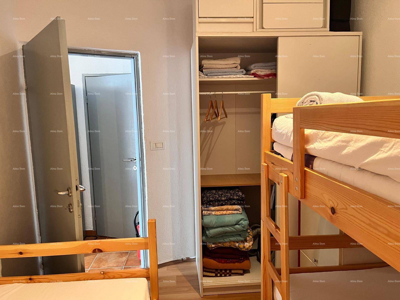 Schlafzimmer mit Etagenbetten und einem offenen Kleiderschrank, der Stauraum bietet.