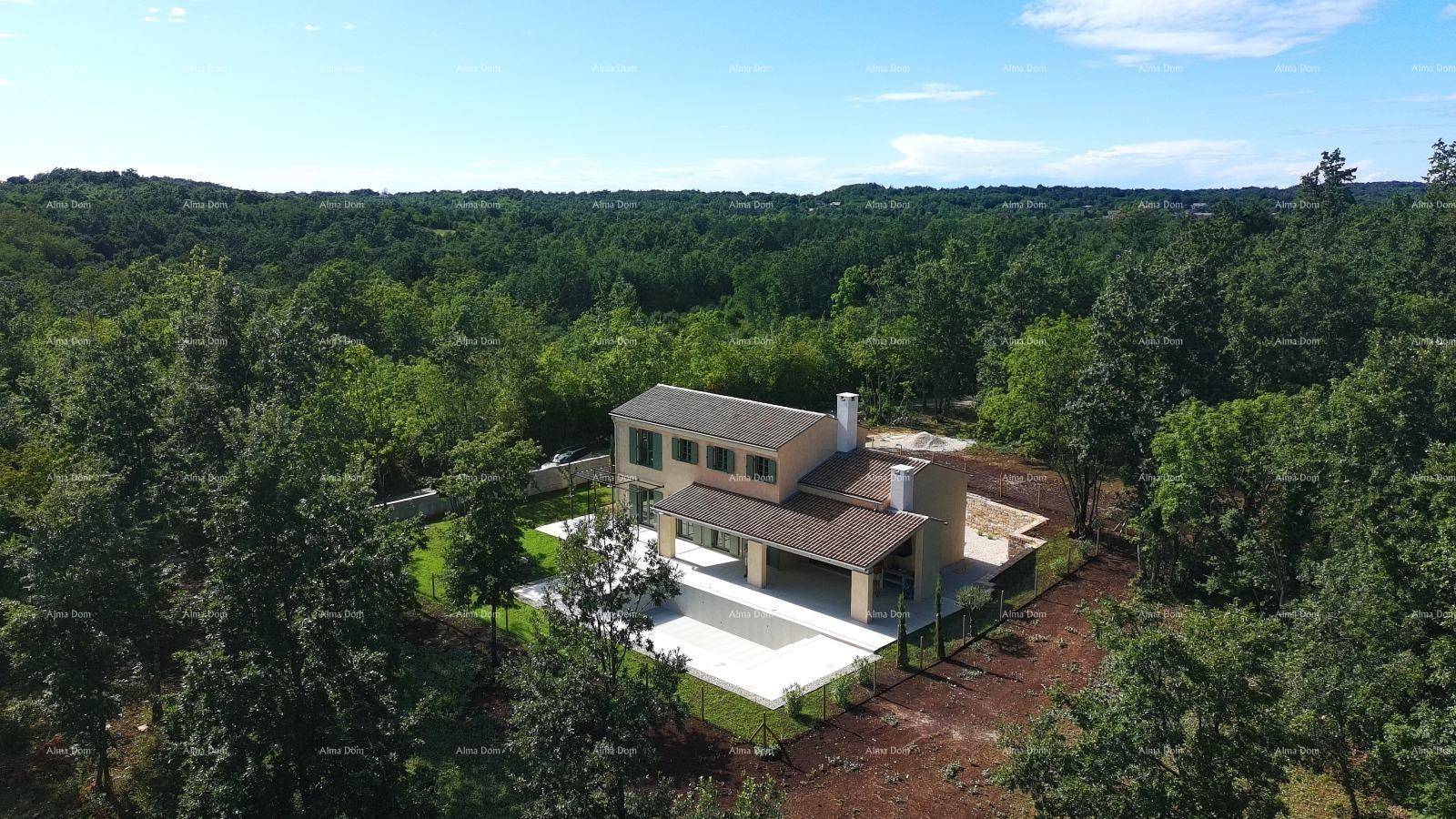 Panoramablick auf ein modernes Haus mit Pool in einer grünen, bewaldeten Umgebung.