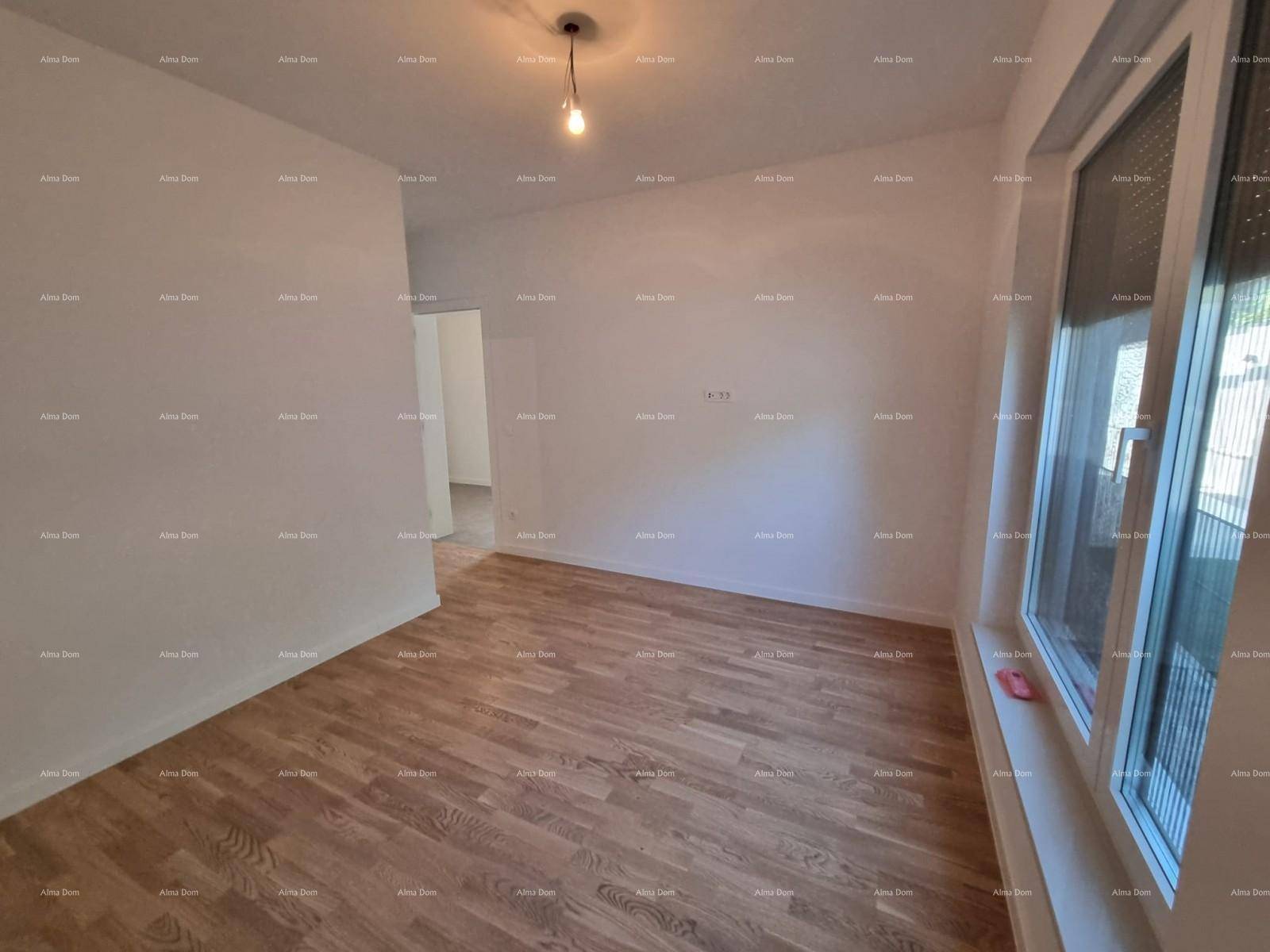 Geräumiges Wohnzimmer mit hellem Parkettboden und großem Fenster.