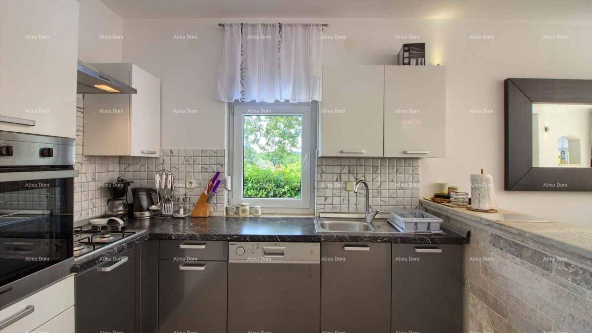 Helle Küche mit modernen Schränken, Spüle, Geschirrspüler und Fenster mit Ausblick.