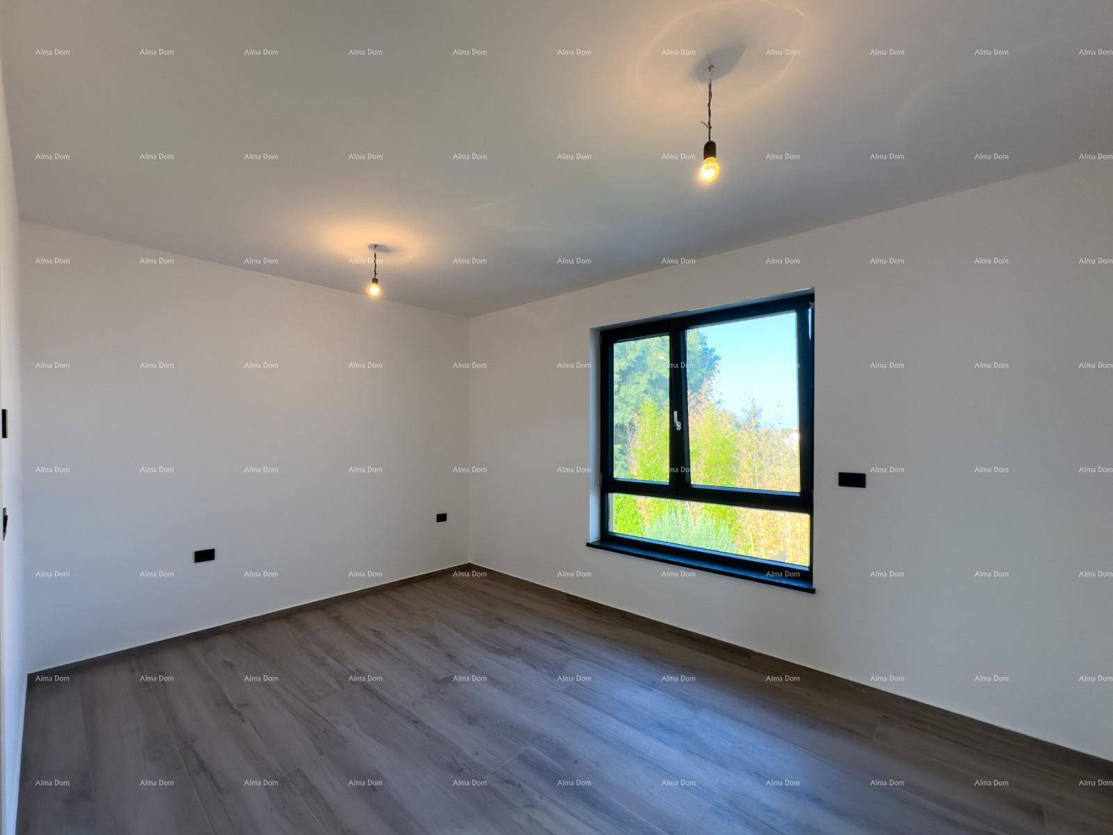 Heller Raum mit Holzoptik-Boden, großem Fenster und Zugang zu einem weiteren Bereich.