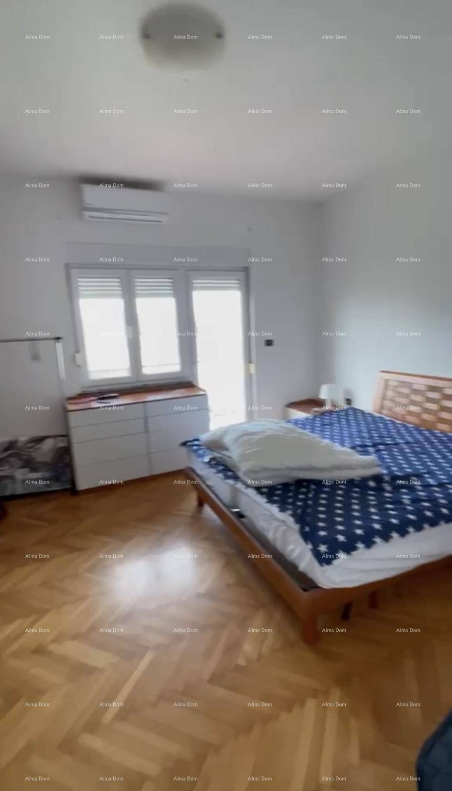 Helles Schlafzimmer mit Holzbett, Kleiderschrank und Zugang zu einem Außenbereich.