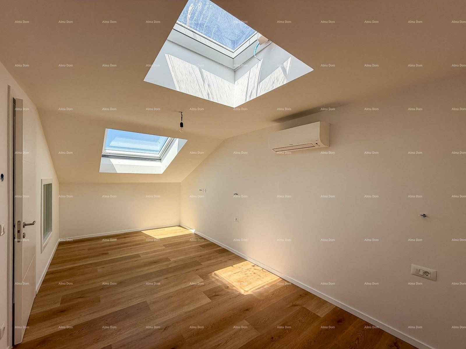 Geräumiges Schlafzimmer mit Holzboden, mehreren Dachfenstern und viel Tageslicht.