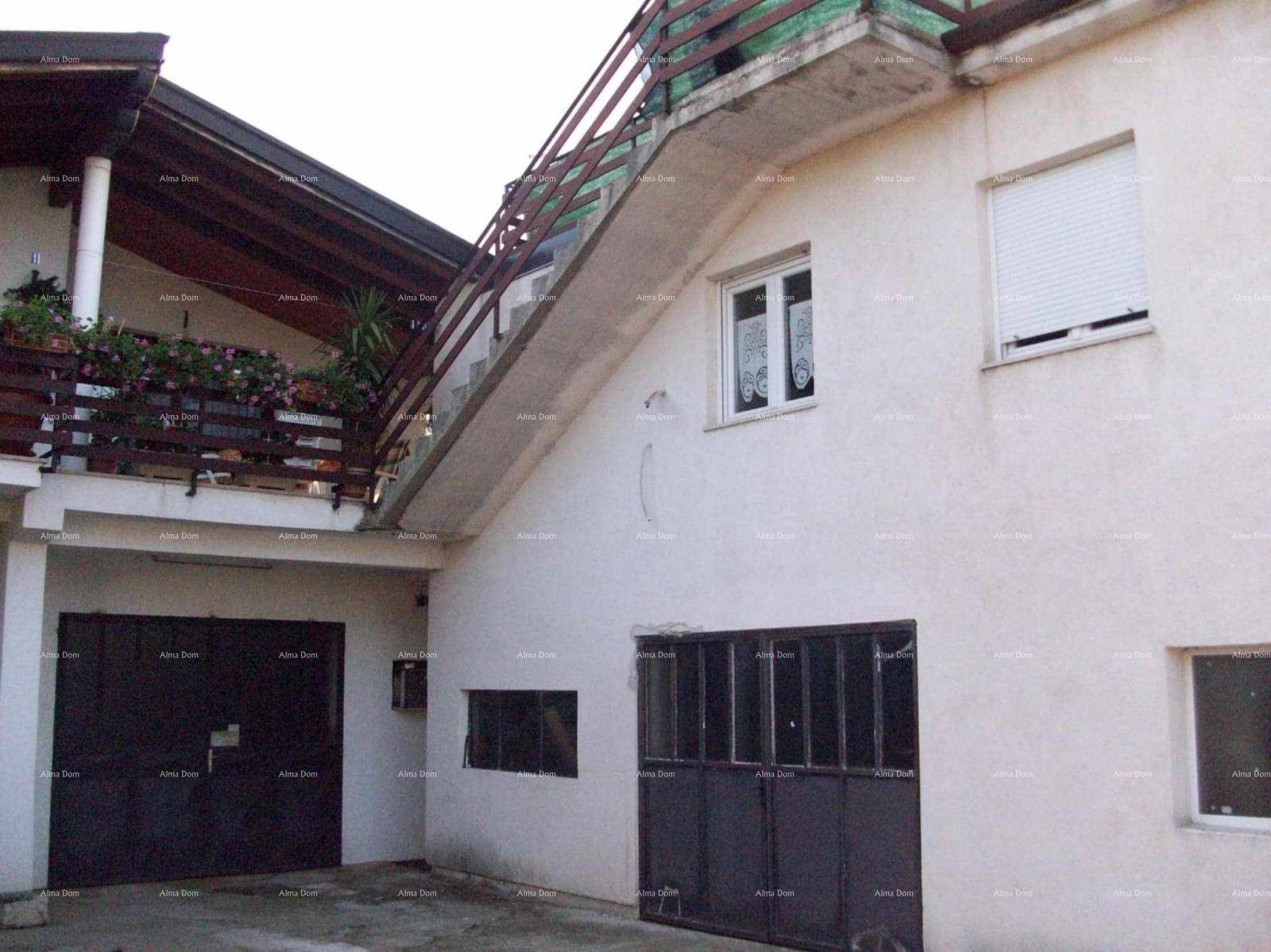 Seitenansicht des Hauses mit Garagentoren und einer Außentreppe zum Obergeschoss.