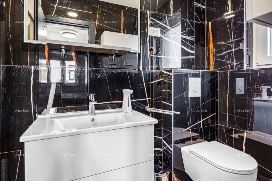 Elegantes Gäste-WC mit schwarzen Marmorfliesen, modernem Waschbecken und Toilette.