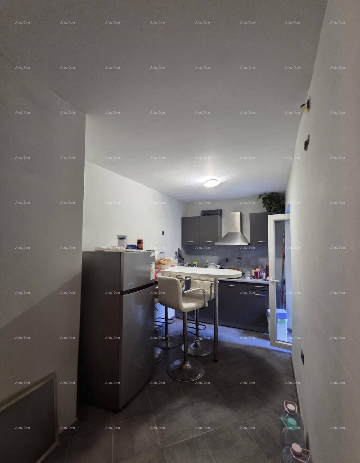 Funktionale Küche mit Fliesenboden, Kühlschrank und einer kleinen Frühstücksbar mit Hockern.