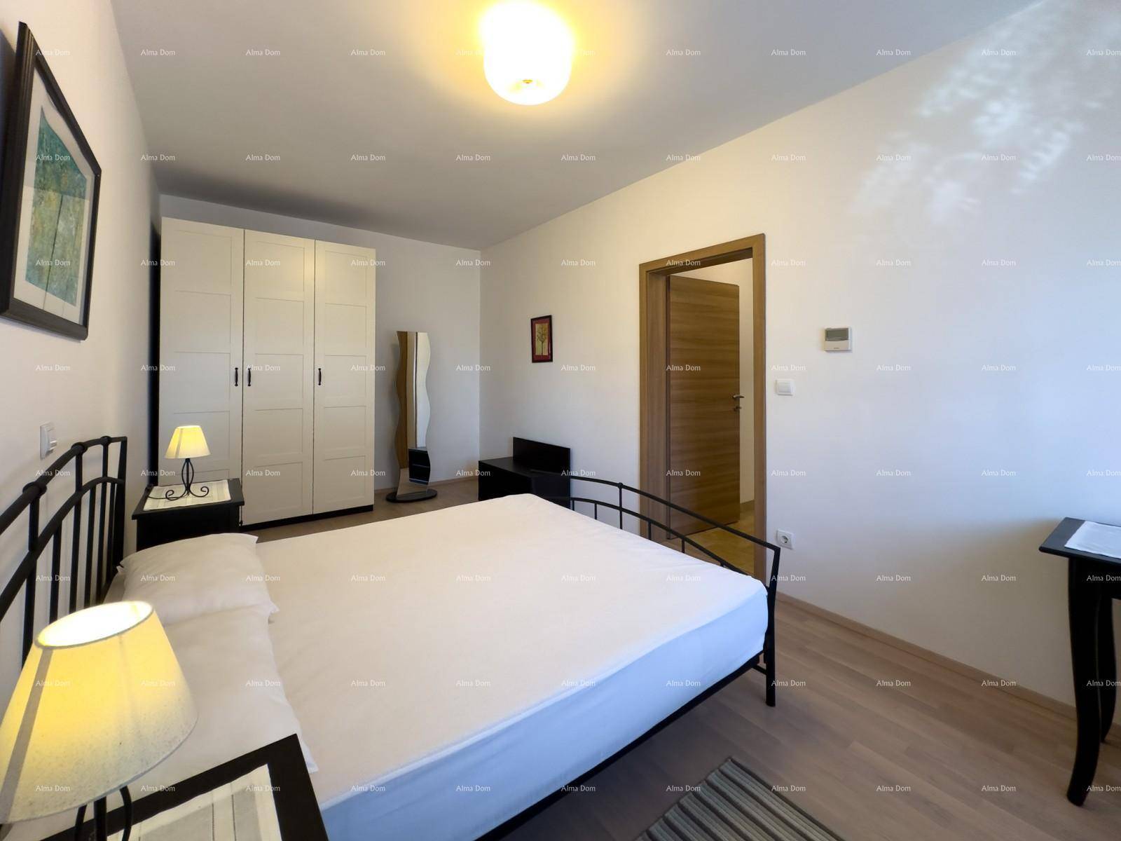Schlafzimmer mit Doppelbett, Nachttischen und einem großen weißen Kleiderschrank.