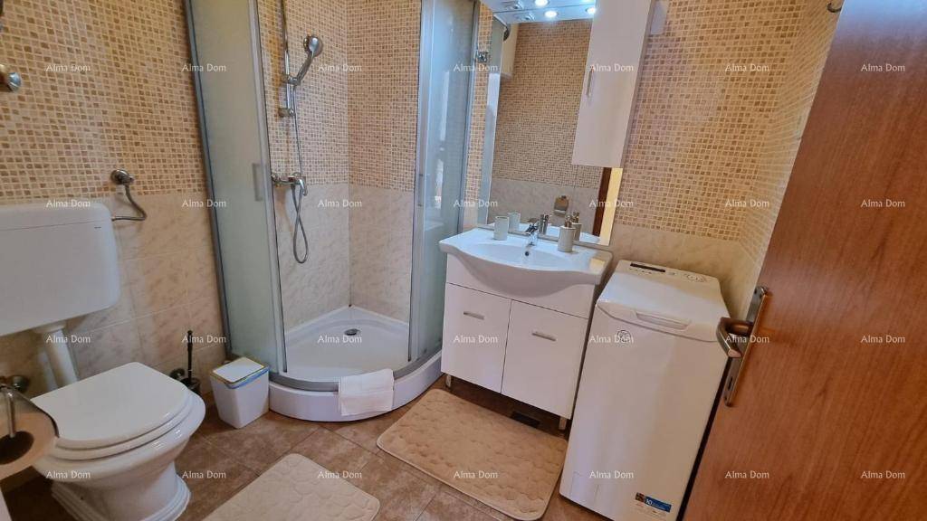 Funktionales Badezimmer mit Duschkabine, Waschbecken und Waschmaschine, hell gefliest.