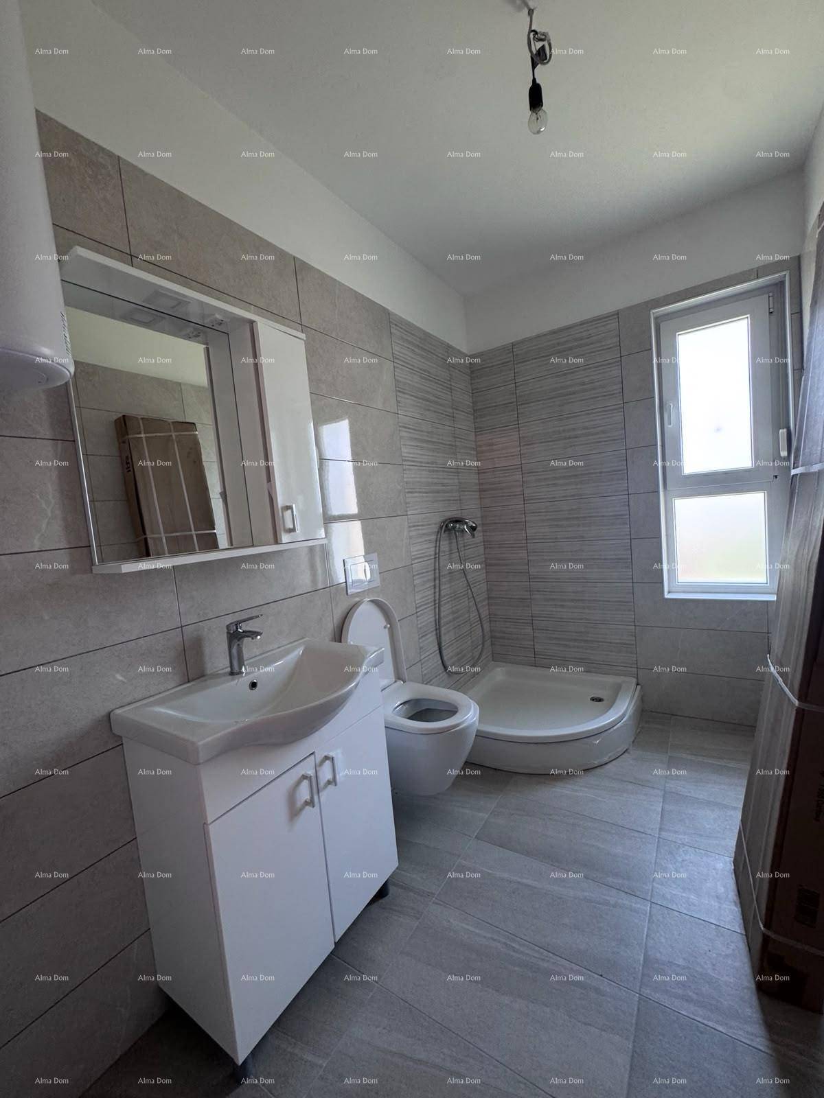 Modernes Badezimmer mit grauen Fliesen, Duschkabine, Waschtisch und Spiegelschrank.