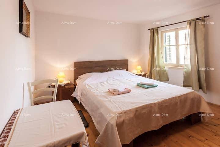 Gemütliches Schlafzimmer mit Doppelbett, Nachttischen und einem Fenster für natürliches Licht.