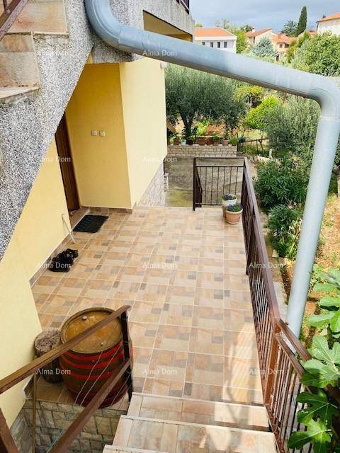 Geflieste Terrasse mit Treppenzugang und Blick auf den Gartenbereich.