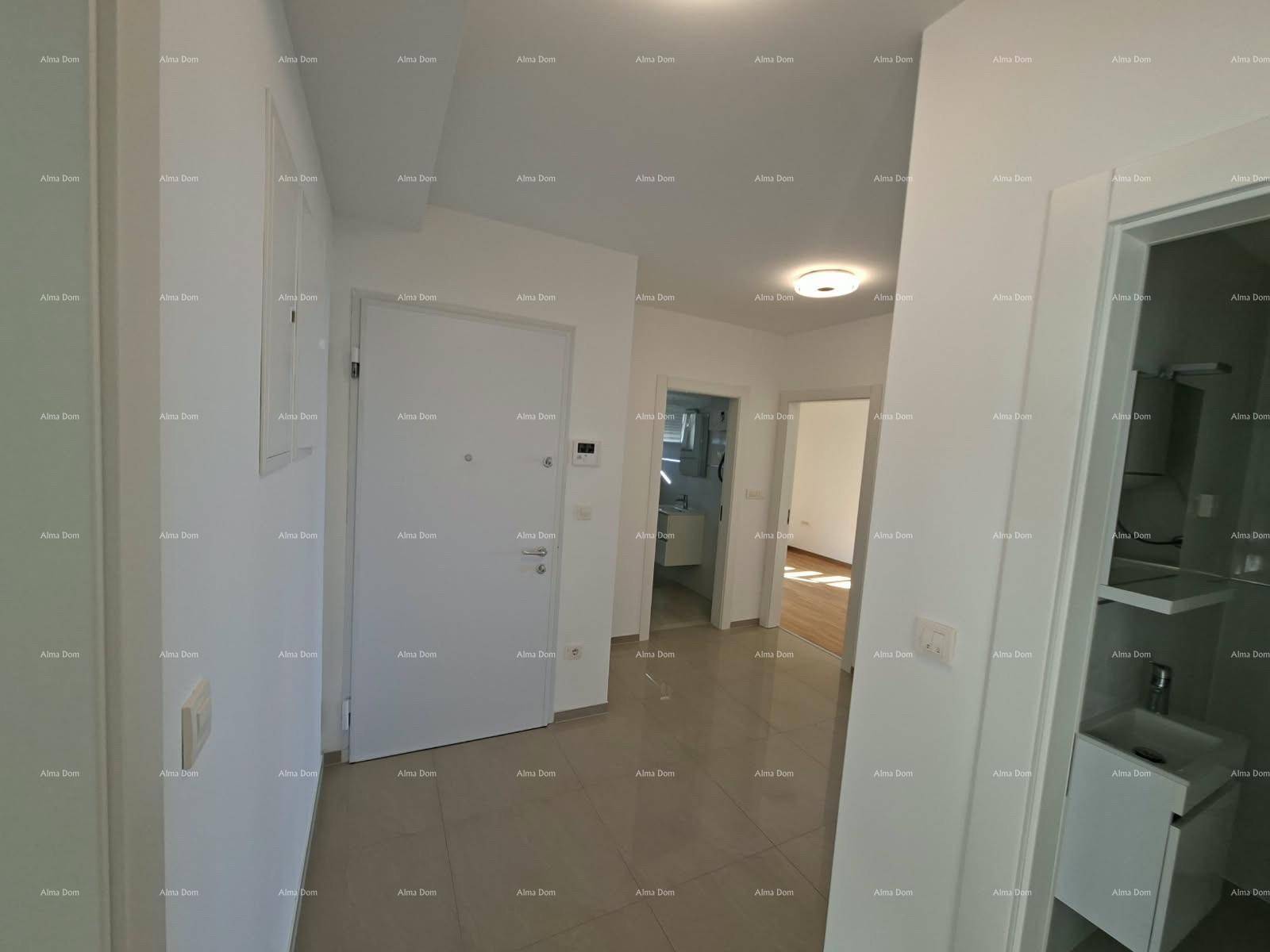 Heller Flur mit modernen Fliesen und Zugang zu verschiedenen Räumen der Wohnung.