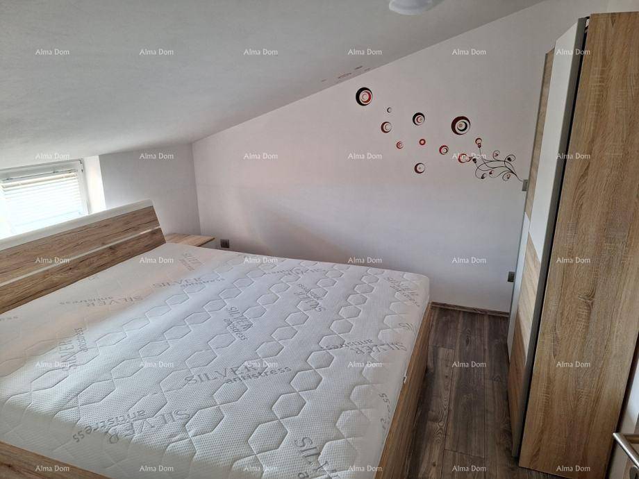 Helles Schlafzimmer mit Doppelbett, Holzschrank und dekorativen Wandstickern unter einer Dachschräge.