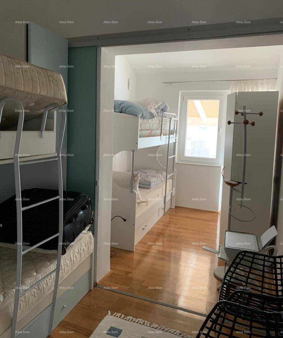 Kinderzimmer mit Etagenbetten und Holzfußboden, bietet Platz für mehrere Schlafplätze und natürliches Licht.