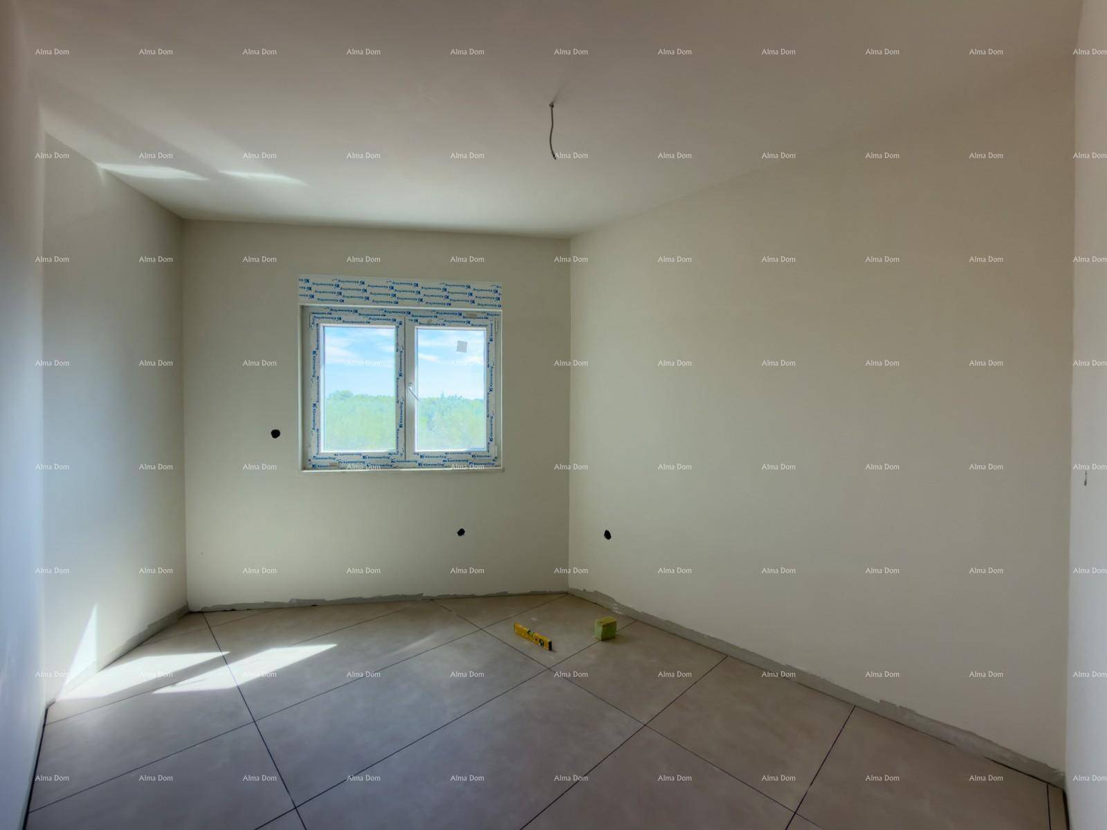 Schlafzimmer im Rohbau mit Fliesenboden und einem Fenster, das viel Tageslicht hereinlässt.