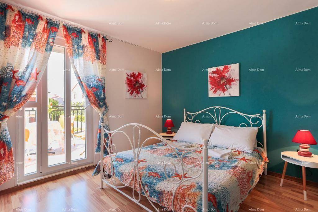 Farbiges Schlafzimmer mit Doppelbett, Holzboden und Zugang zu einem kleinen Balkon.