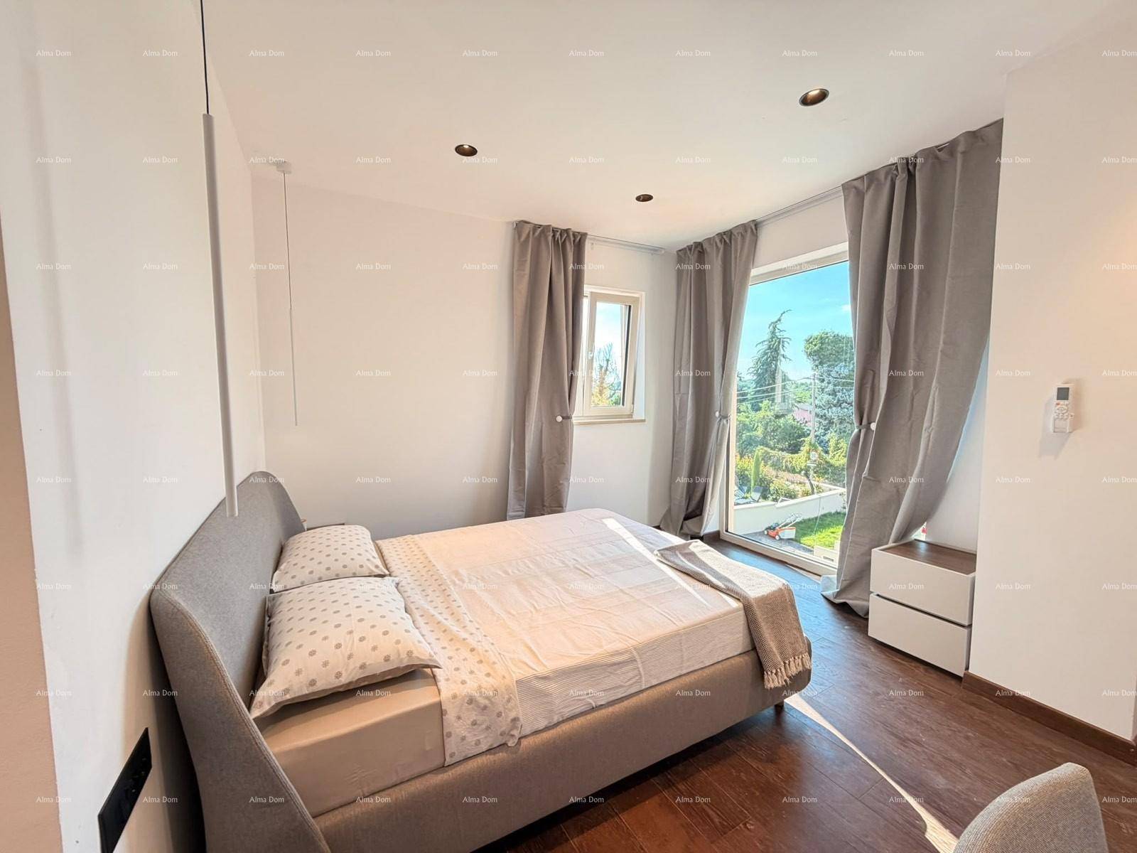 Helles Schlafzimmer mit Zugang zum Balkon und Blick ins Grüne.