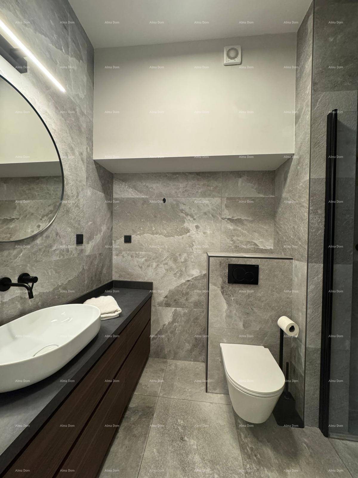Modernes Badezimmer mit grauen Fliesen, wandhängendem WC und stilvollem Aufsatzwaschbecken.